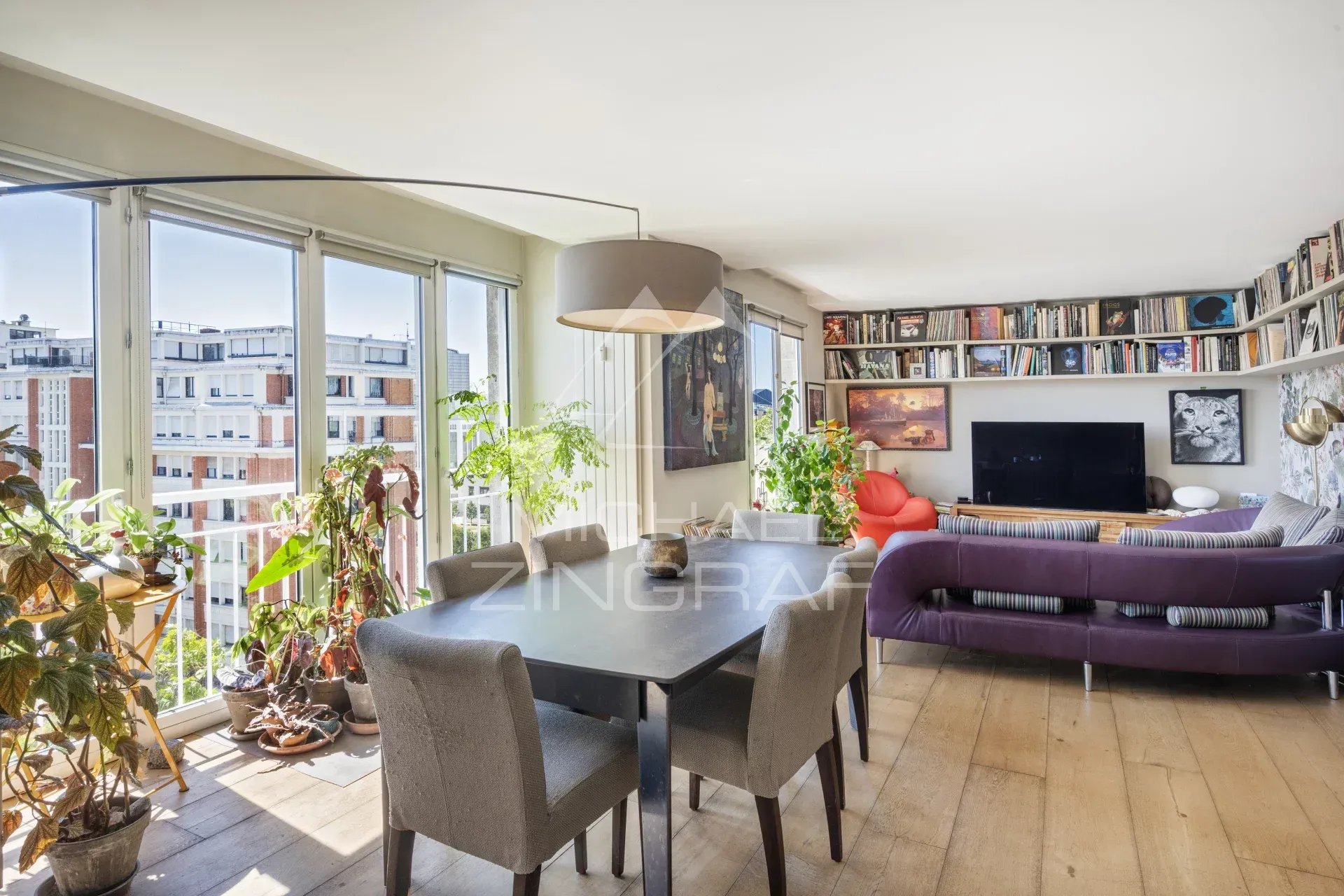Intérieur d'un penthouse à Paris 15, salon avec table à manger et plantes.