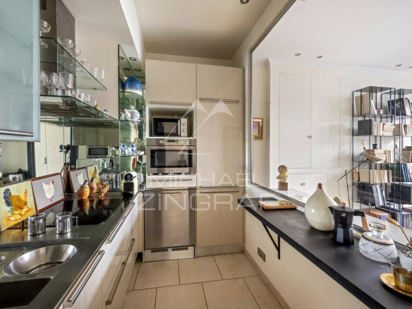 Cuisine équipée d'un appartement à vendre, avec meubles modernes et appareils électroménagers.