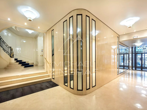 Hall d'entrée d'un immeuble moderne avec escalier et ascenseur à Paris.