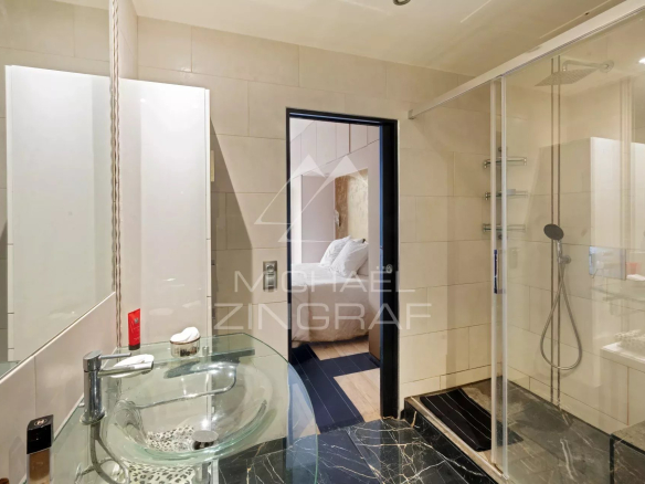 Salle de bain moderne avec douche et lavabo, appartement à Paris IX