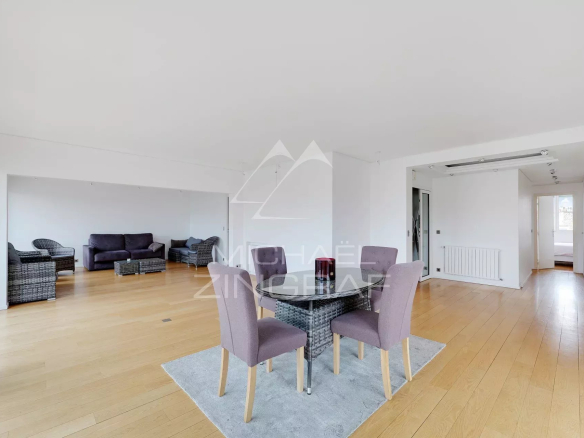 Intérieur d'un appartement moderne avec salon spacieux et coin repas, parquet en bois.