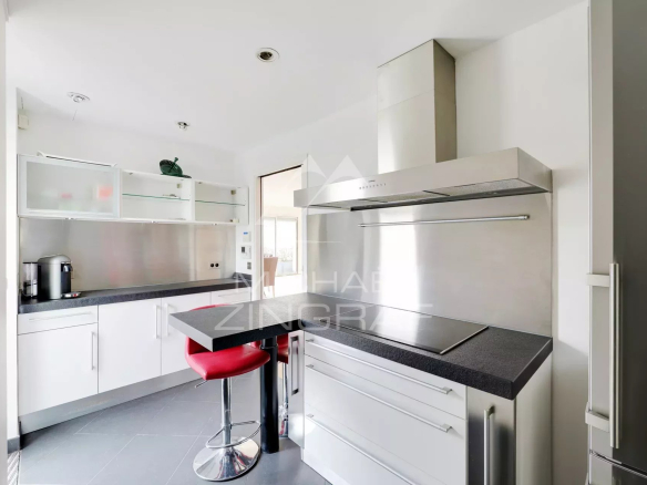 Cuisine moderne avec bar et chaises hautes, appartement à Paris 6ème.