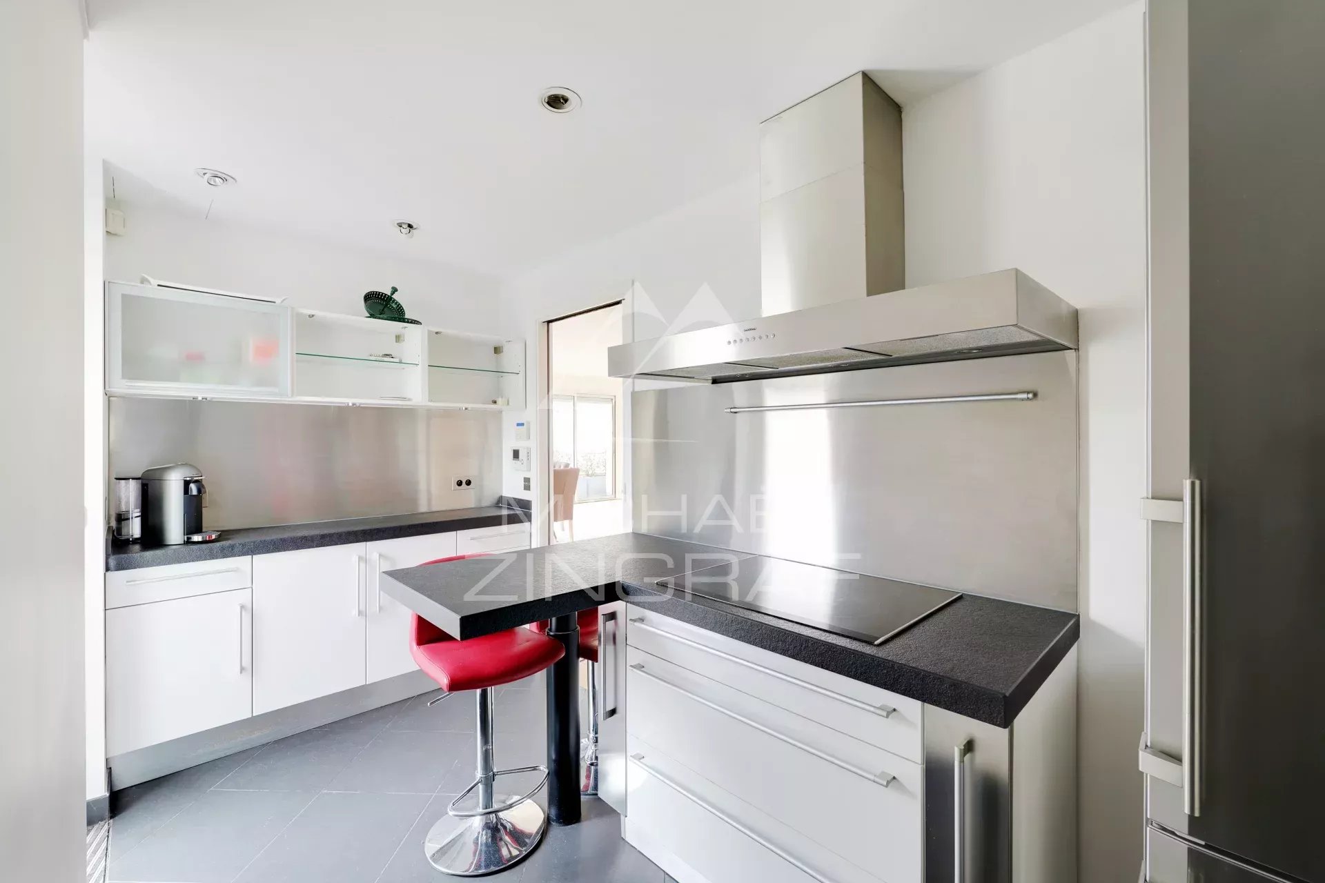 Cuisine d’un appartement à Paris 6ème Cuisine moderne avec bar et chaises hautes, appartement à Paris 6ème.