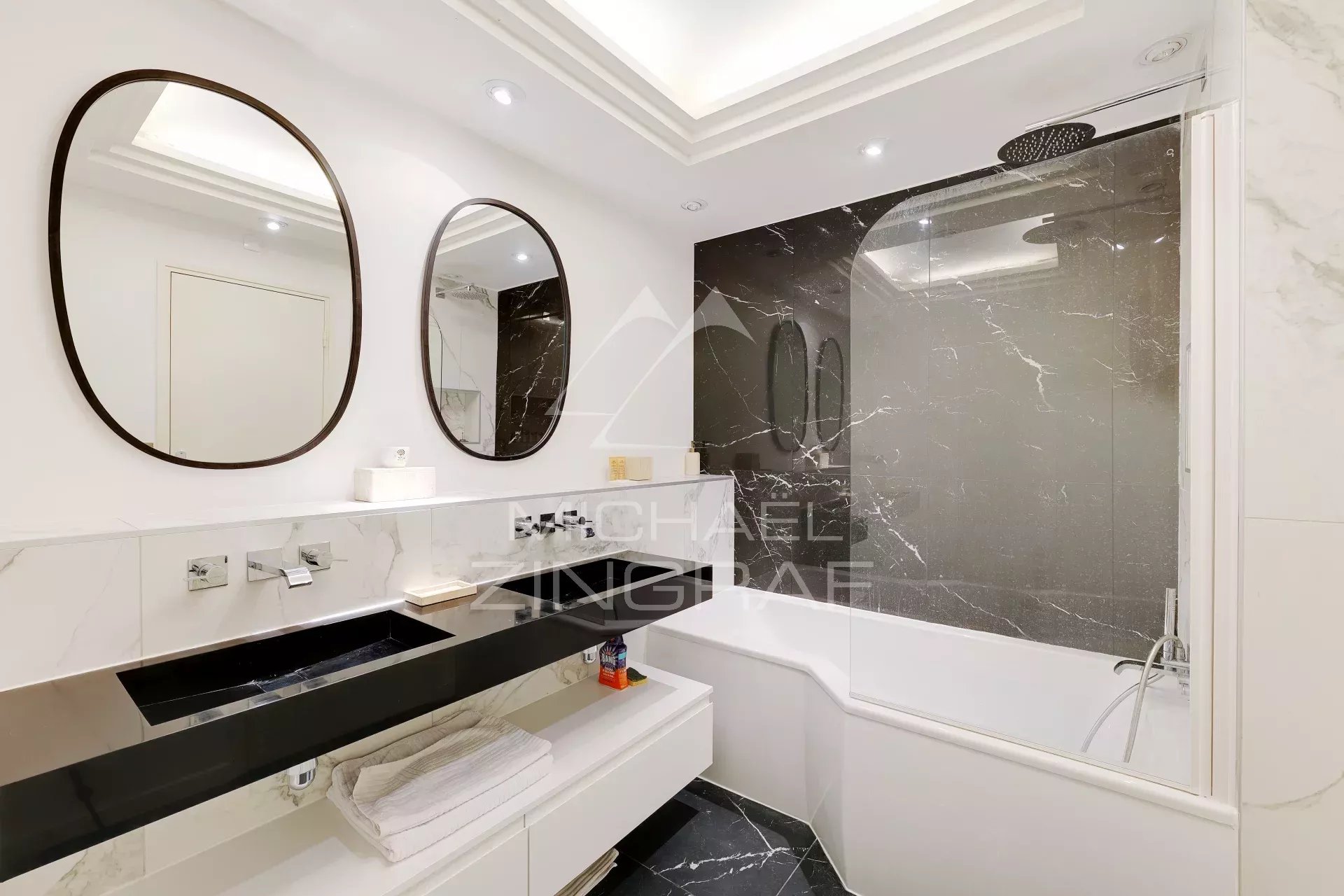 Salle de bain moderne Salle de bain moderne avec baignoire et lavabo, murs en marbre noir et blanc.