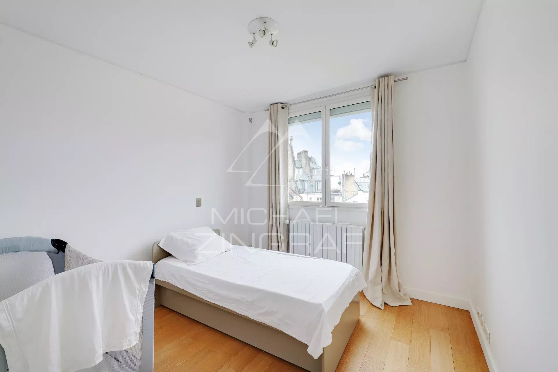 Chambre d’appartement à Paris Chambre d'un appartement moderne à Paris, avec un lit simple et une fenêtre.