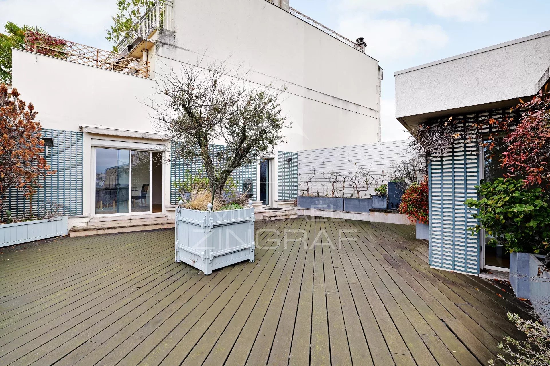 Terrasse d’appartement à Paris 6ème Terrasse spacieuse d'un appartement au dernier étage à Paris, avec plantes et mobilier extérieur.