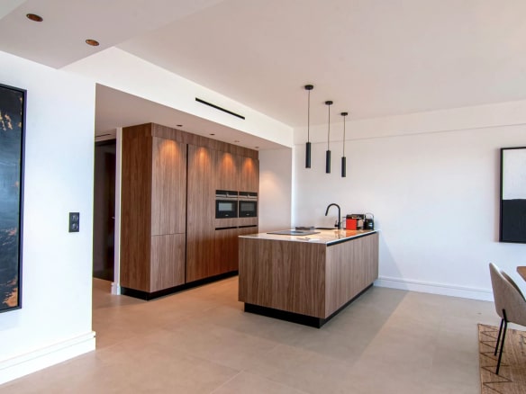 Interior of a modern apartment with open kitchen and contemporary furniture.