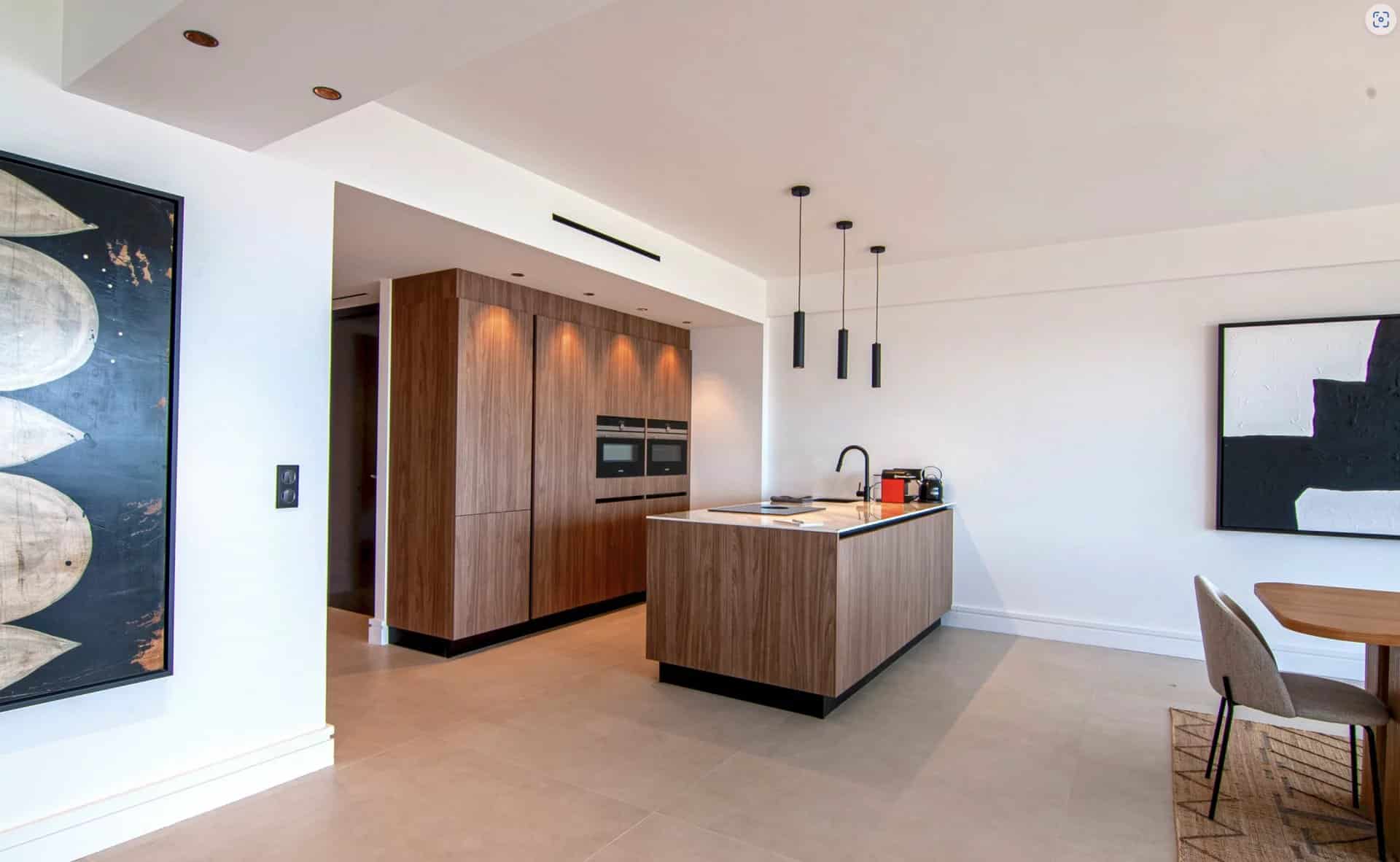 Interior of a modern apartment with open kitchen and contemporary furniture.
