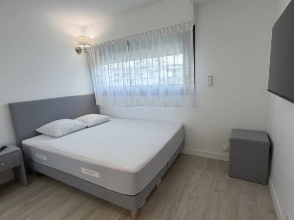 Chambre d'appartement lumineux avec lit double et mobilier moderne à Cannes.
