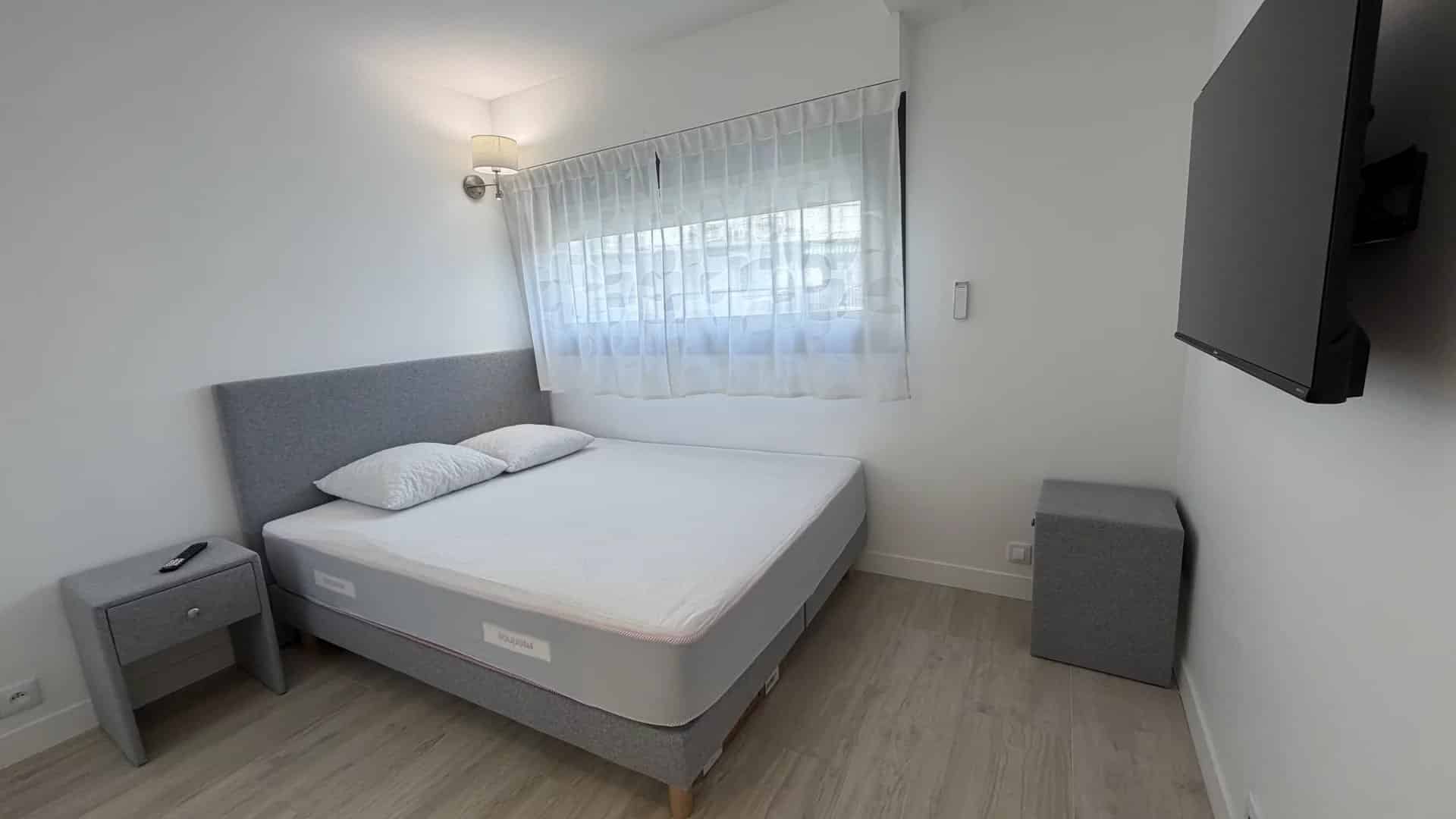 Chambre d'appartement lumineux avec lit double et mobilier moderne à Cannes.