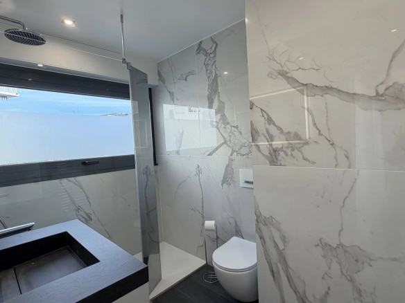 Salle de bain moderne avec carrelage en marbre et douche à l'italienne.