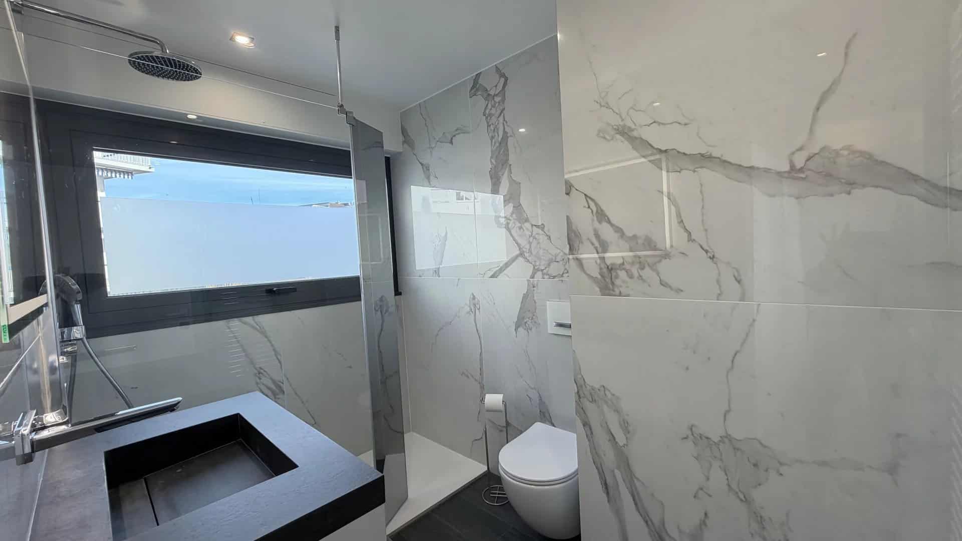 Salle de bain moderne avec carrelage en marbre et douche à l'italienne.