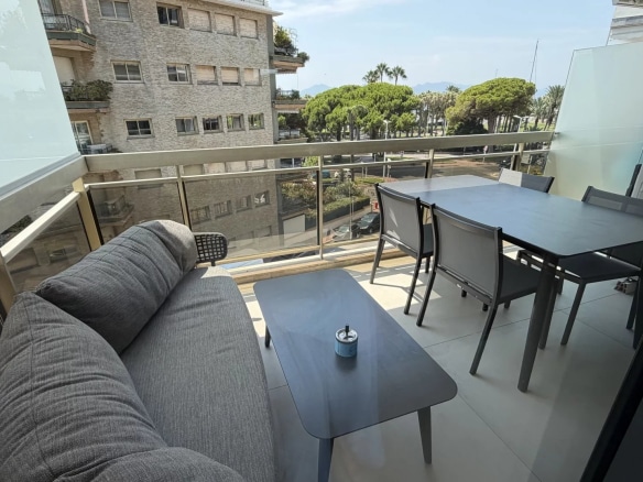 Apartment terrace in Cannes with outdoor furniture and a view of the Palm Beach district.