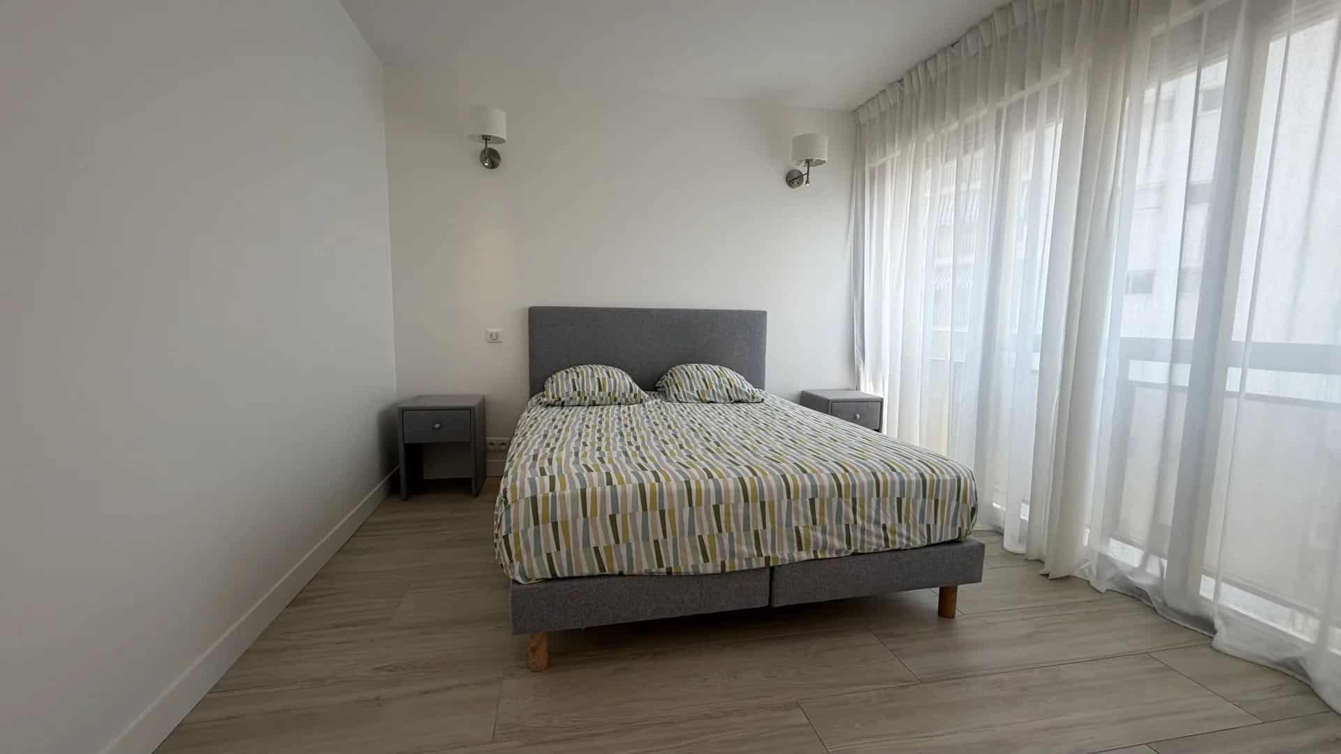 Apartment room in Palm Beach Room in a bright apartment with a double bed and sheer curtains.