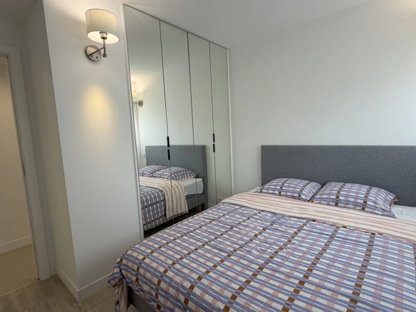 Room in a bright apartment in Cannes with double bed and mirror.