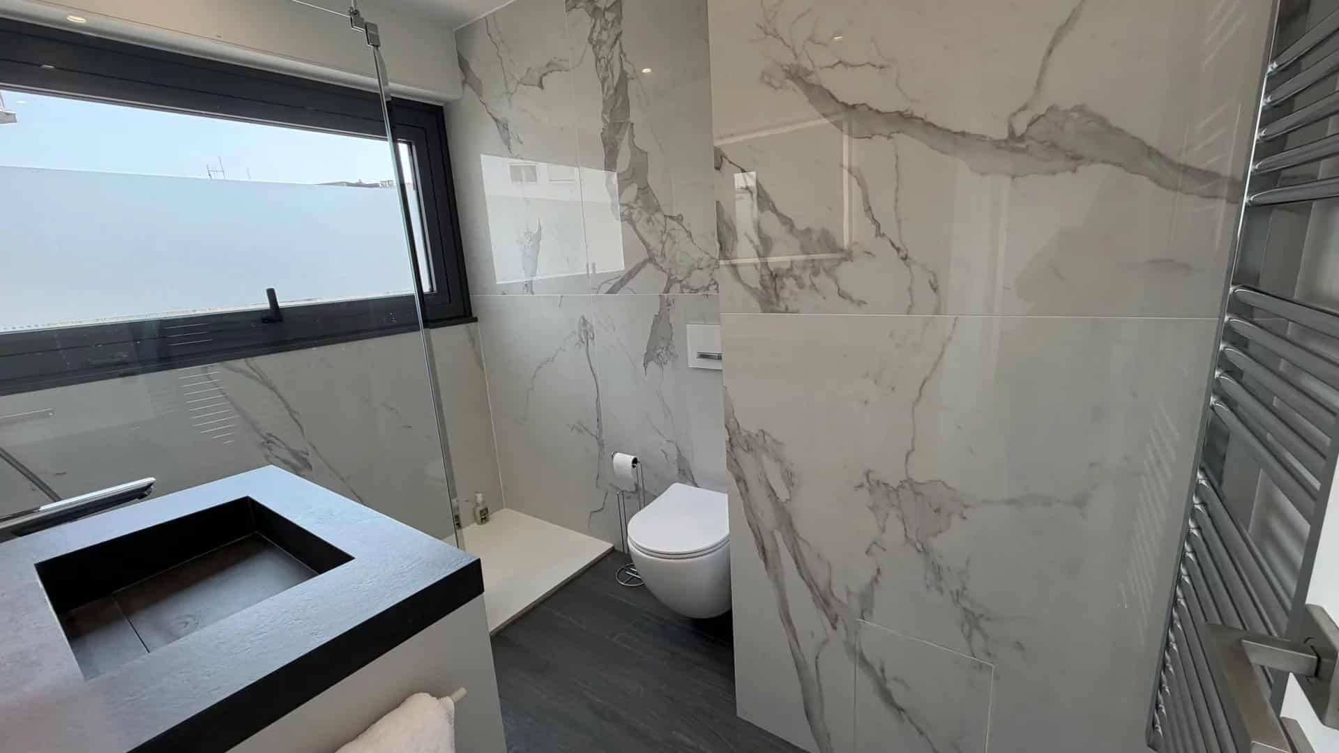 Modern bathroom in Cannes Modern bathroom with marble tiles and walk-in shower.
