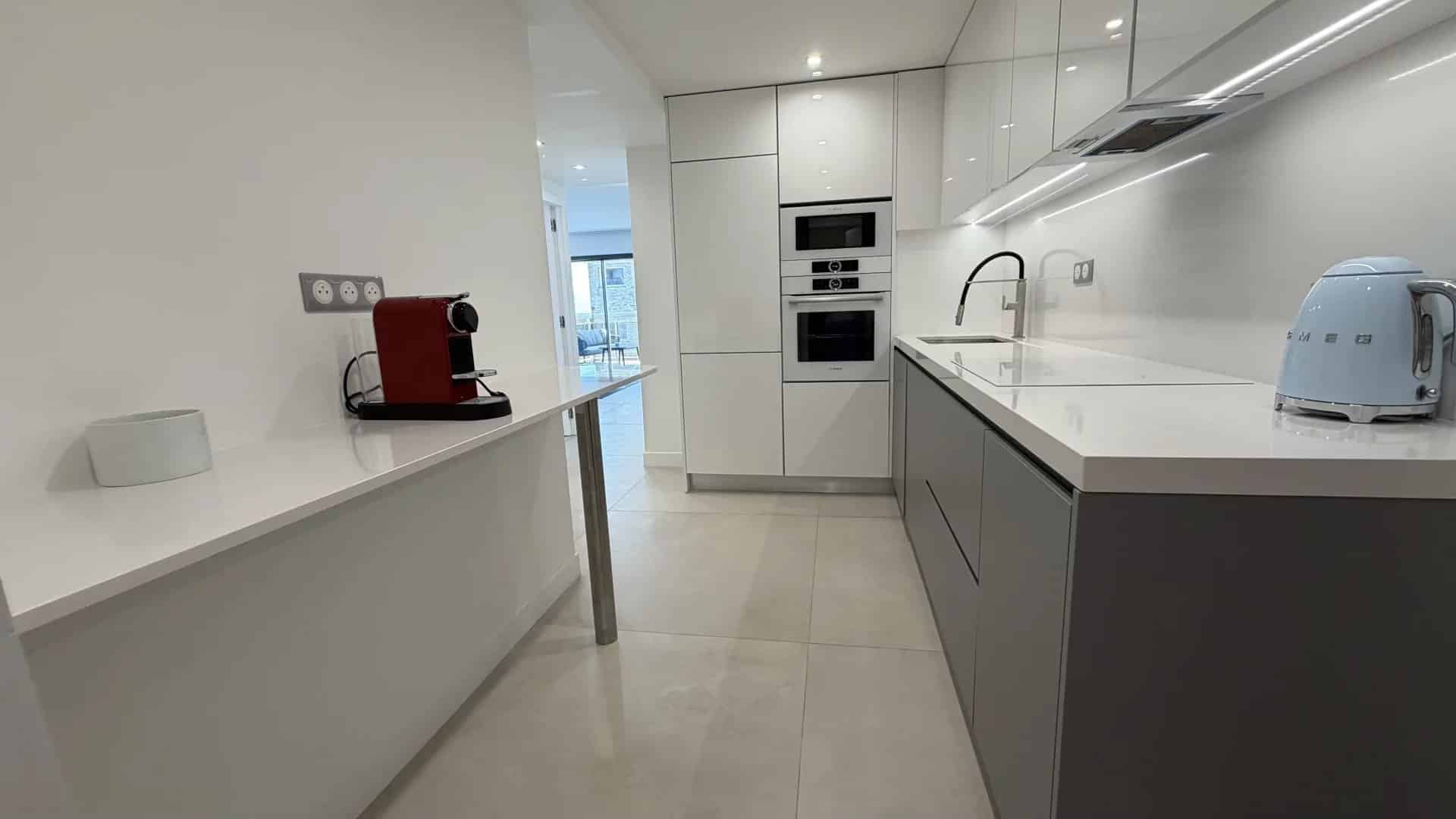 Kitchen of an apartment in Cannes Modern and bright kitchen in an apartment in Cannes, with integrated appliances and quartz worktop.