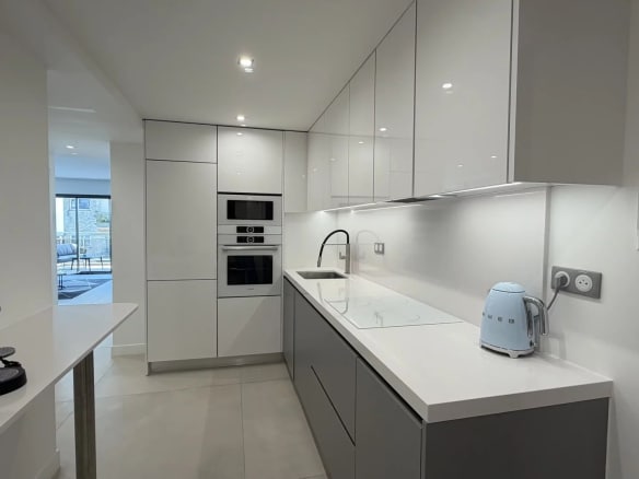 Modern and bright kitchen in an apartment in Cannes, with integrated appliances and a light worktop.