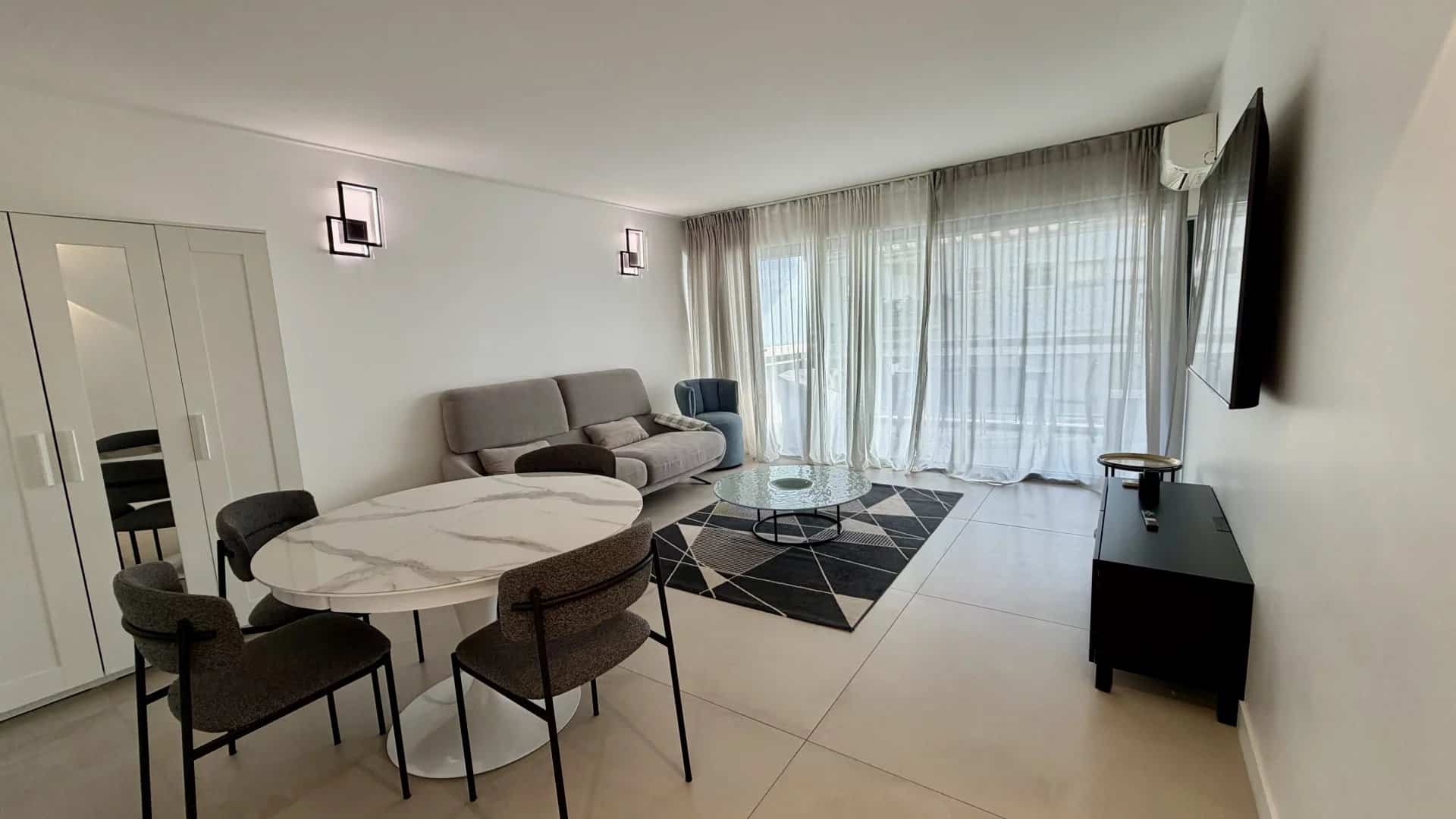 Bright apartment in Cannes Interior of a bright apartment in Cannes, with living room, dining table and terrace.