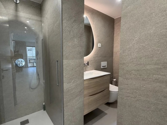 Modern bathroom with walk-in shower and wooden vanity unit.