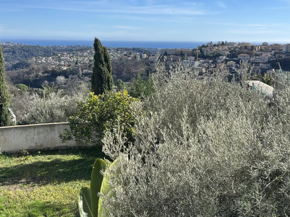 Unobstructed view of the sea and hills from a villa surrounded by vegetation in Vence.