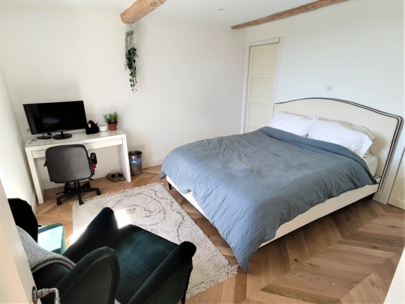 Chambre d'une maison rénovée à Mougins, avec lit, bureau et décoration moderne.
