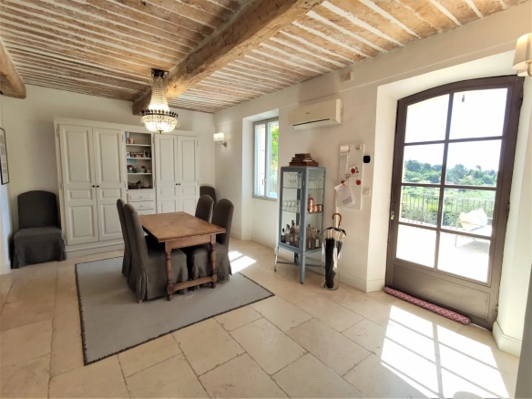 Intérieur d'une maison rénovée avec un salon lumineux et une table à manger en bois.