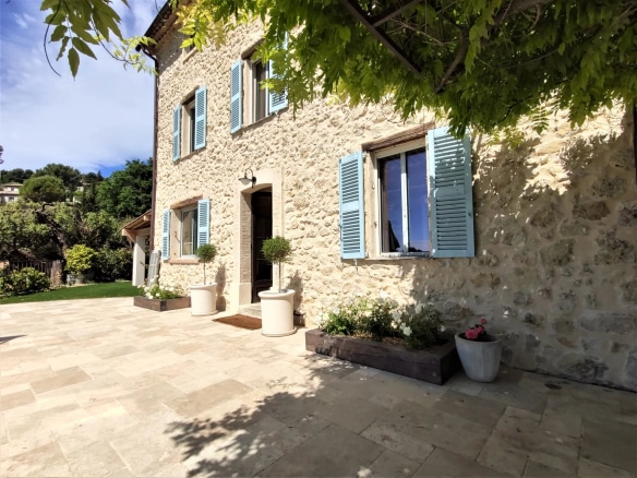 Maison en pierre avec volets bleus, patio et jardin à Mougins.