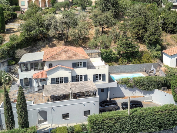 Villa de charme à Vence avec piscine et vue mer, entourée d'un jardin arboré.