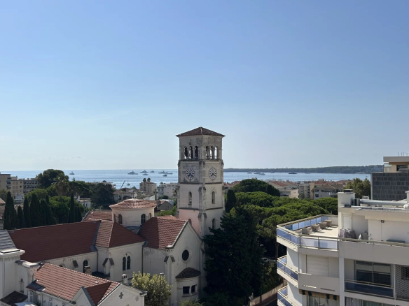 Sea view from a terrace in Cannes, with buildings and a church in the foreground.