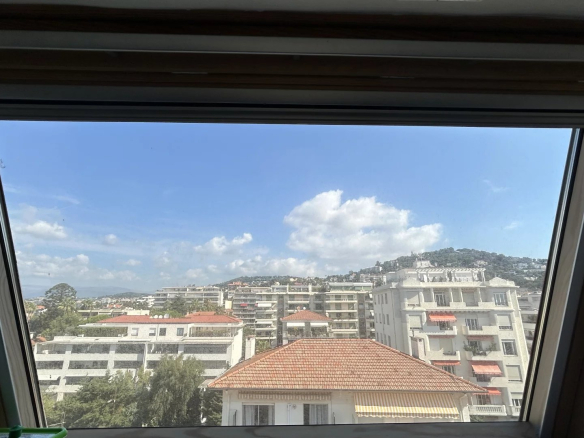 View from a window of an apartment in Cannes, showing buildings and the blue sky.