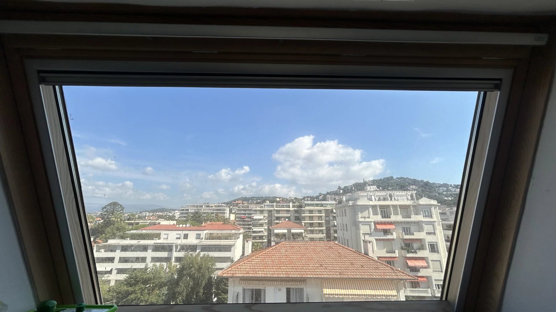 View from an apartment in Cannes View from a window of an apartment in Cannes, showing buildings and the blue sky.