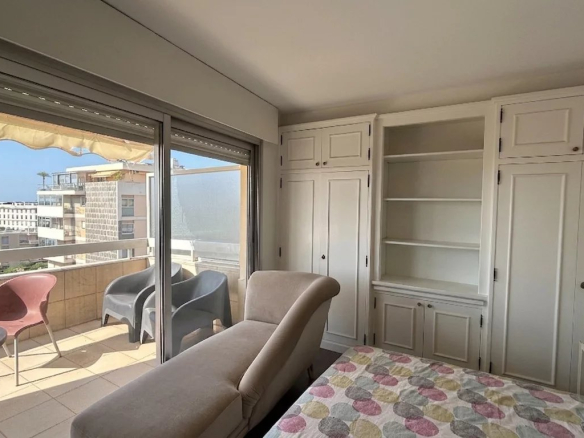 Interior of an apartment with sea views in Cannes, comprising a living room and a balcony.