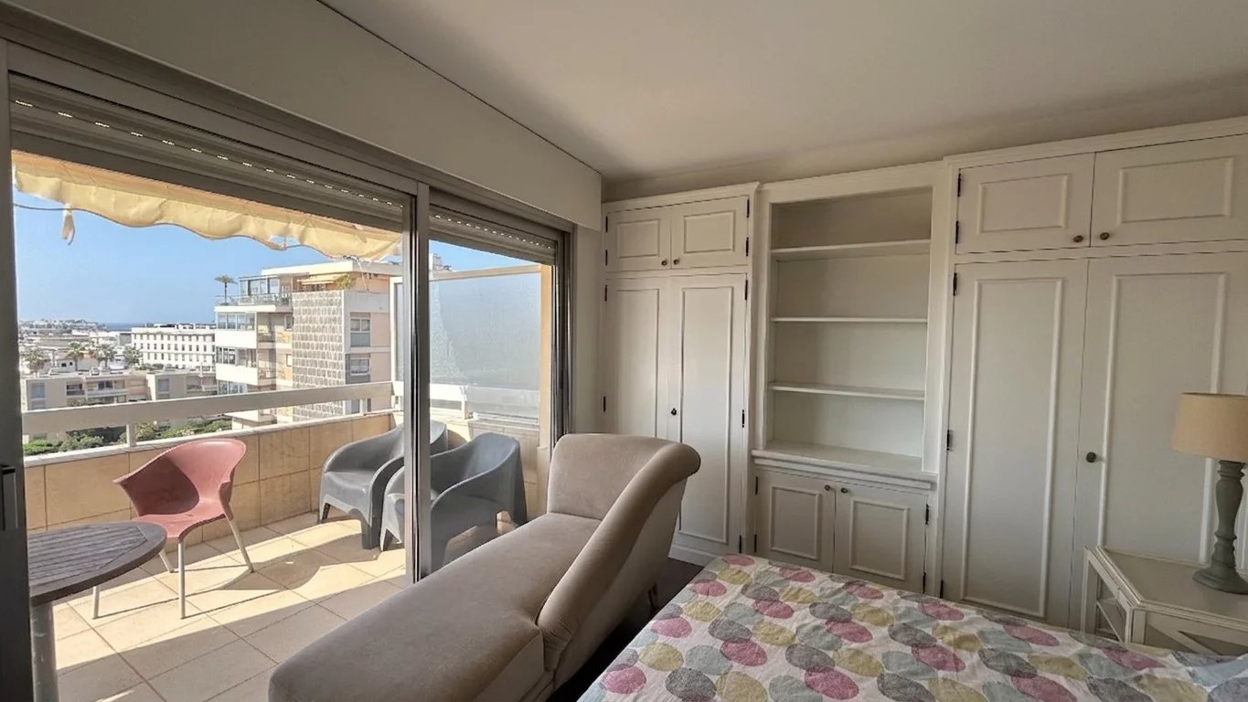 Apartment in Cannes with sea view Interior of an apartment with sea views in Cannes, comprising a living room and a balcony.