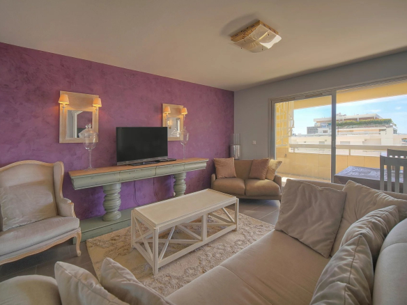 Intérieur d'un appartement à Cannes avec un salon lumineux et un accès à une terrasse.