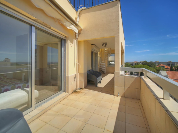 Terrasse d'un appartement à Cannes avec vue sur la mer, mobilier extérieur visible.