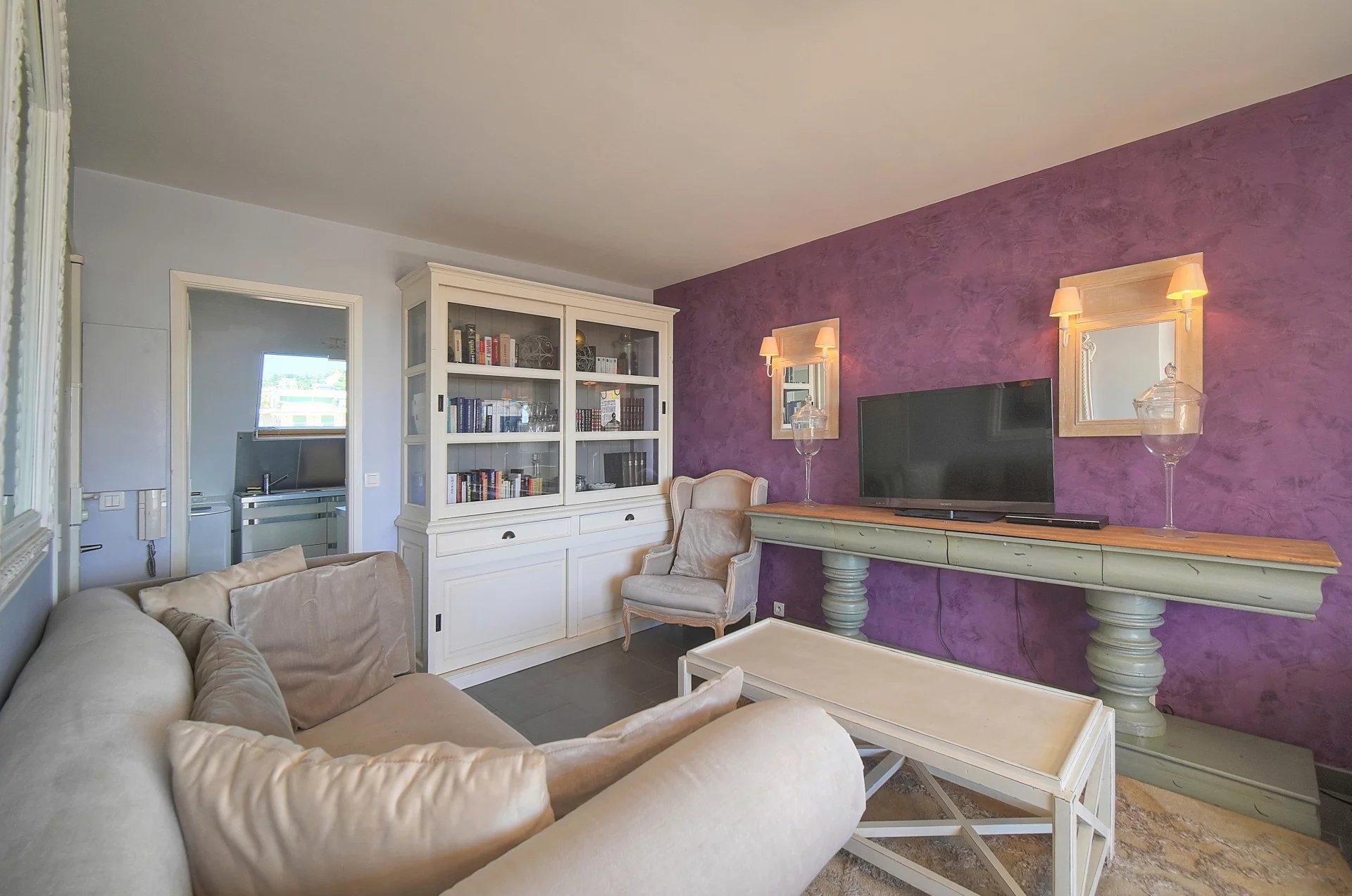 Intérieur d'un appartement à Cannes avec un salon et une télévision.