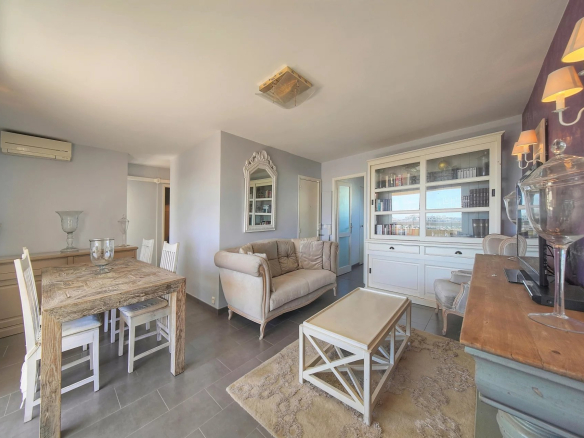 Intérieur d'un appartement à Cannes avec salon, salle à manger et vue sur la mer.