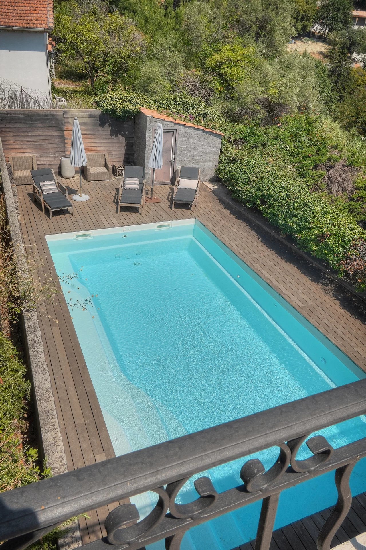 Villa avec piscine à Vence Vue de la piscine et du jardin d'une villa à Vence, avec des chaises longues et des parasols.