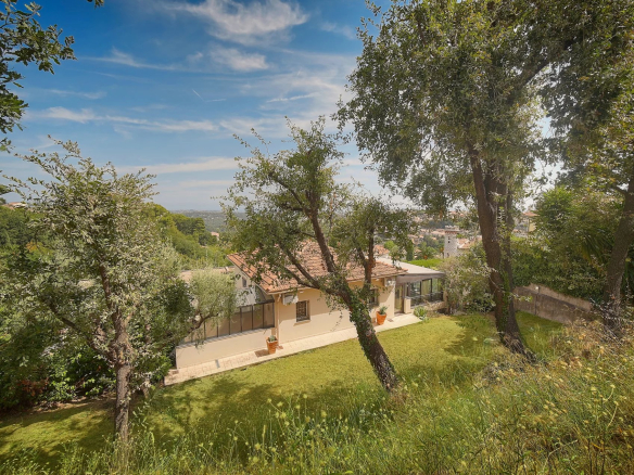 Vue d'une villa de charme avec jardin et arbres, située à Vence, France.