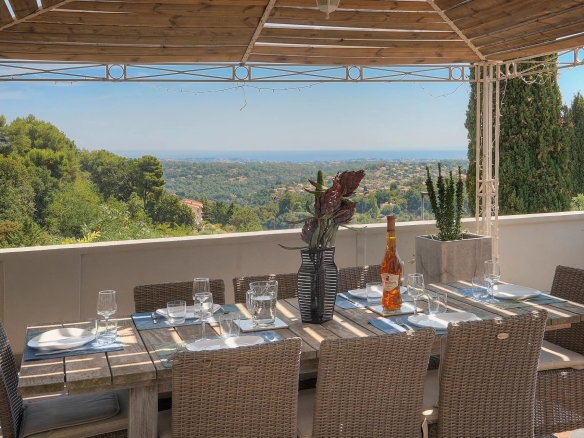 Terrasse avec vue sur la mer et table à manger en bois à Vence.