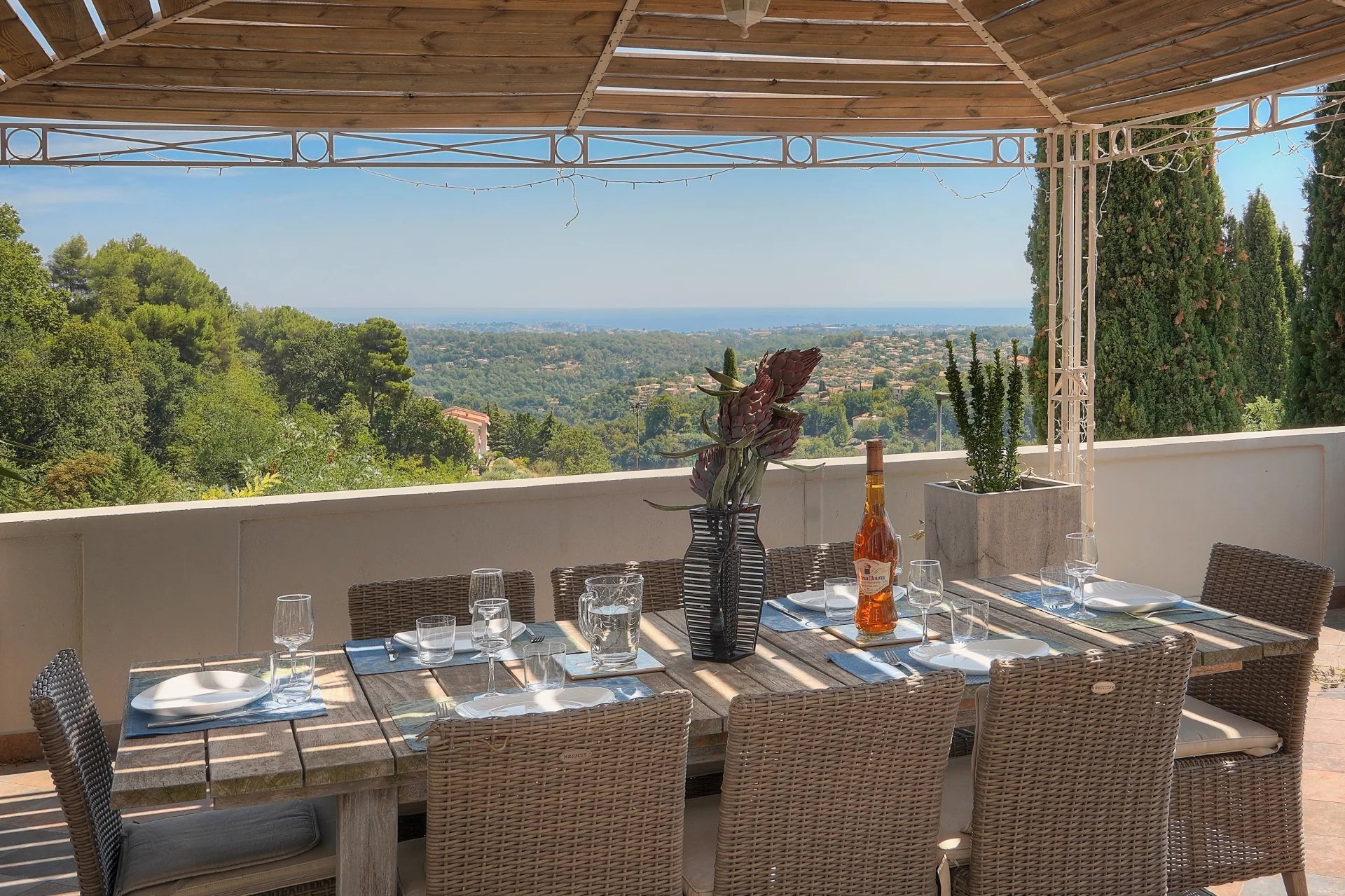 Terrasse avec vue à Vence Terrasse avec vue sur la mer et table à manger en bois à Vence.