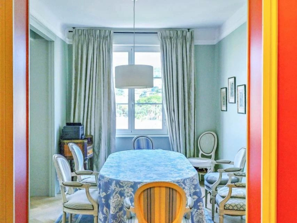 Salle à manger d'un appartement bourgeois à Cannes, avec une table ronde et des chaises élégantes.