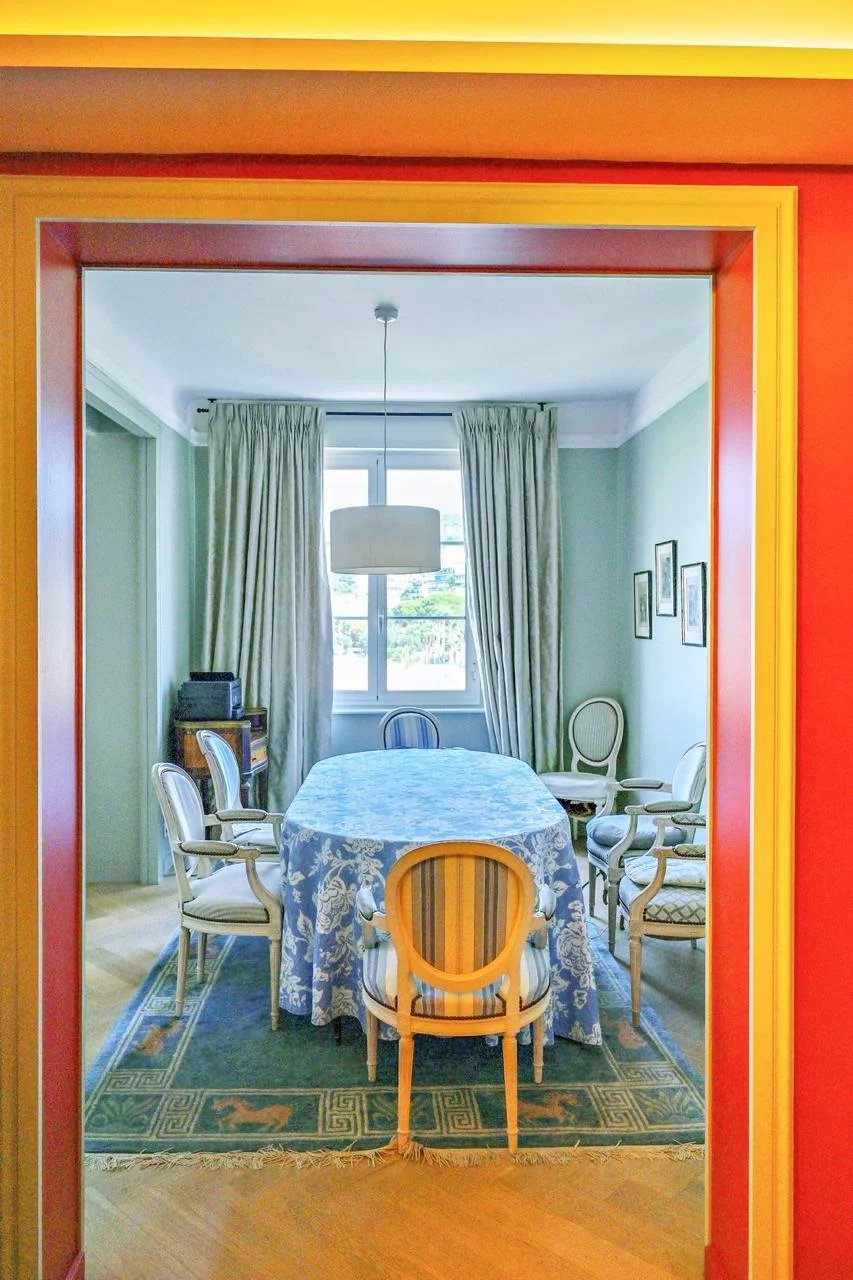 Salle à manger d'un appartement bourgeois à Cannes, avec une table ronde et des chaises élégantes.