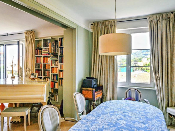 Intérieur d'un appartement bourgeois à Cannes avec salle à manger et bibliothèque.
