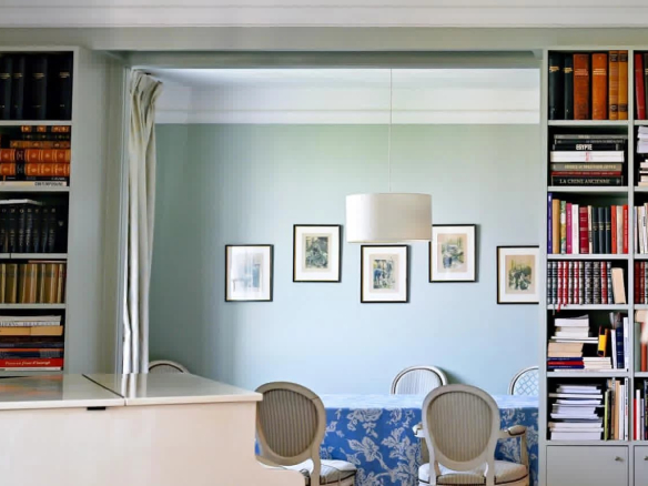 Intérieur d'un appartement bourgeois à Cannes avec bibliothèque et salle à manger lumineuse.