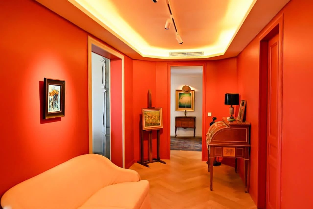 Hall d'entrée d'un appartement bourgeois à Cannes, murs rouges, éclairage moderne.