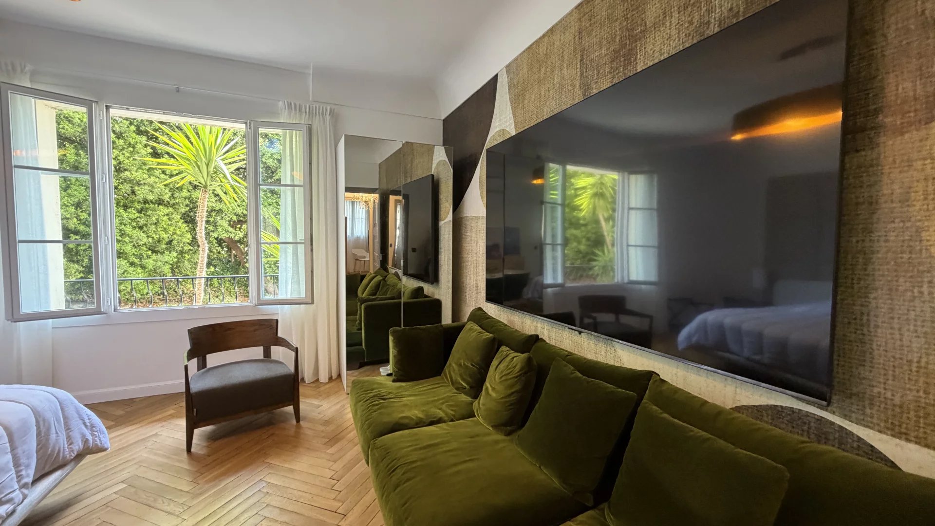 Appartement rénové à Cannes Intérieur d'un appartement rénové à Cannes avec un salon moderne et des fenêtres donnant sur un jardin