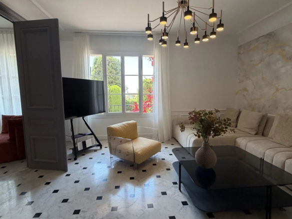 Intérieur d'un appartement rénové à Cannes avec un salon moderne et lumineux.