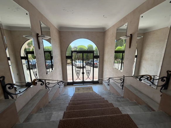 Escalier d'entrée d'une résidence bourgeoise à Cannes avec vue sur l'extérieur.